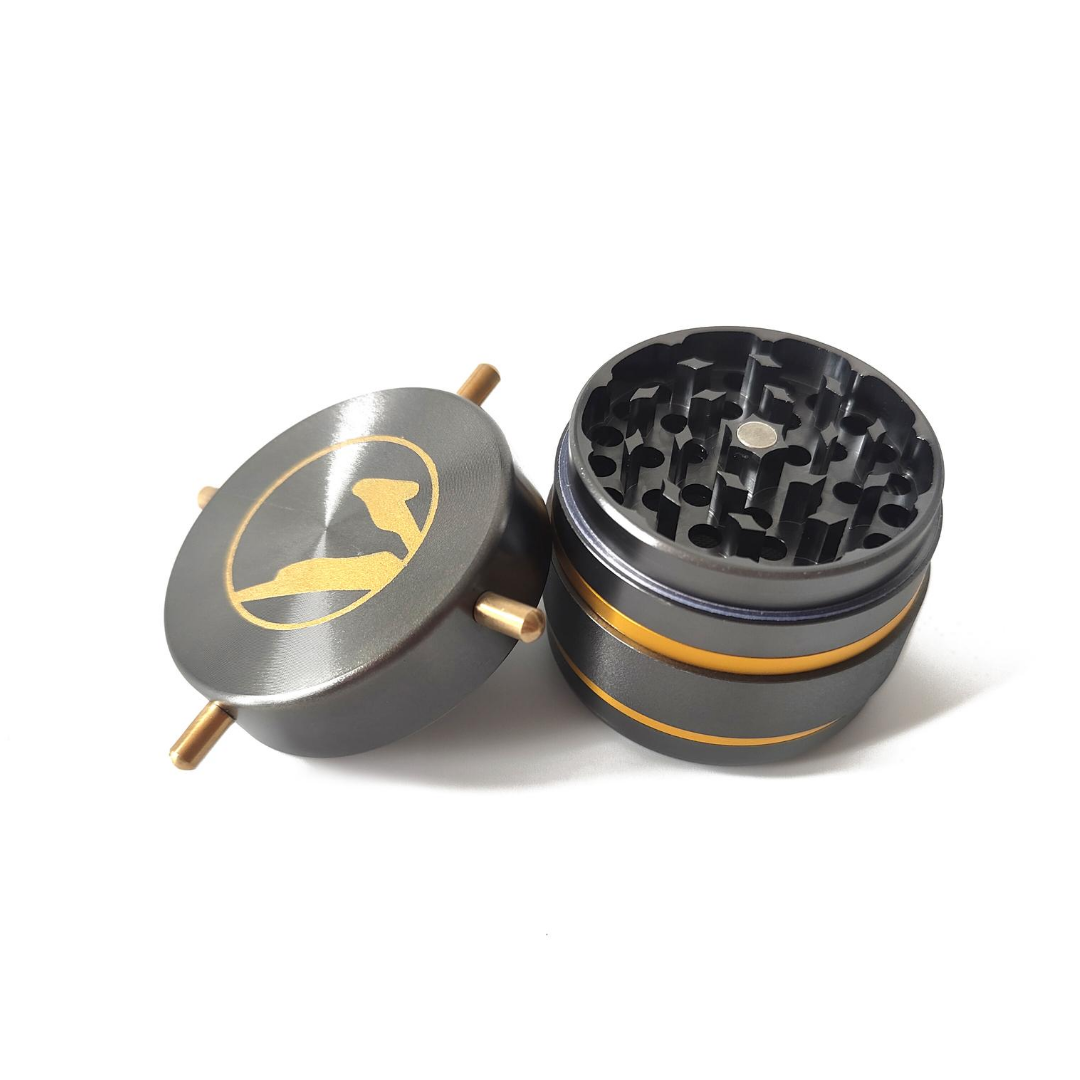 Twisty Herb Grinder with Gold Logo Lid Open to Reveal the Metal Grinding Teeth